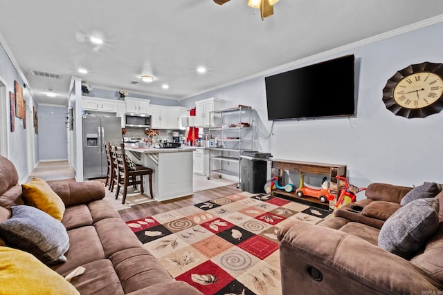 living room featuring ceiling fan, light hardwood / wood-style floors, and ornamental molding