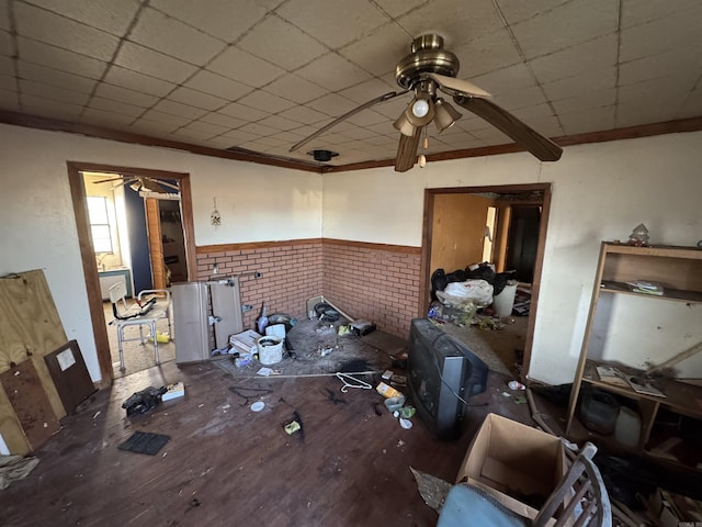 misc room featuring hardwood / wood-style flooring, ceiling fan, a drop ceiling, and ornamental molding