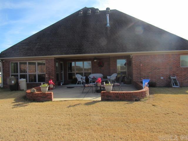 back of property with a yard and a patio area