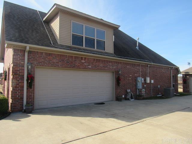 view of side of property featuring a garage and central air condition unit