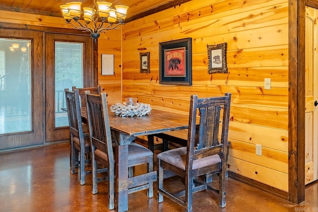 dining area featuring wood walls, wooden ceiling, and a chandelier