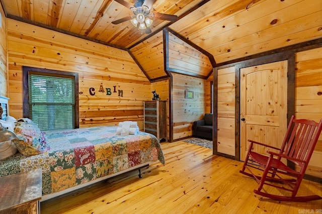 bedroom featuring hardwood / wood-style floors, ceiling fan, wood walls, and lofted ceiling