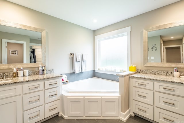 bathroom featuring a tub, tile patterned flooring, and vanity