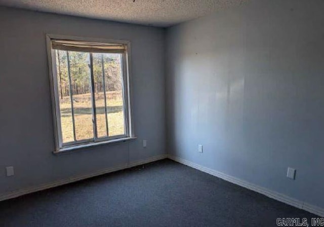 carpeted spare room with a textured ceiling