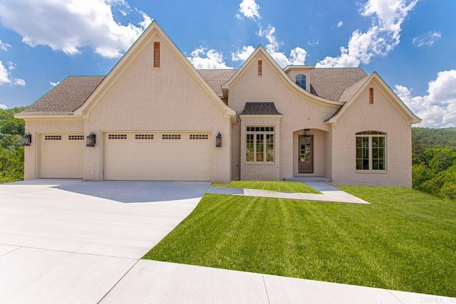 french provincial home with a garage and a front yard