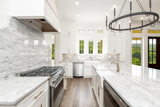 kitchen featuring white cabinets, appliances with stainless steel finishes, and tasteful backsplash