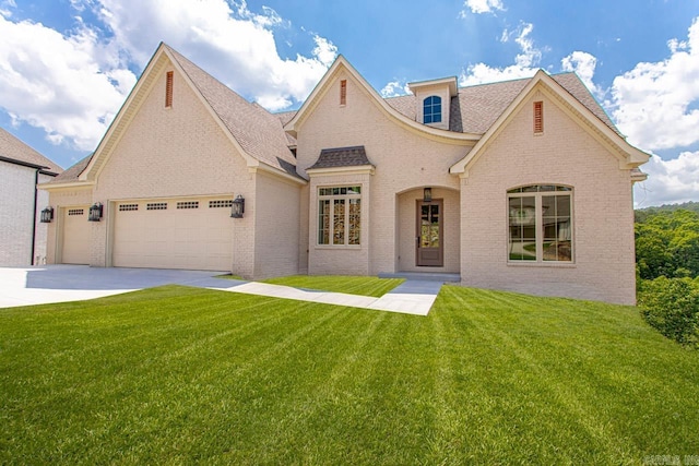 french provincial home with a front yard and a garage