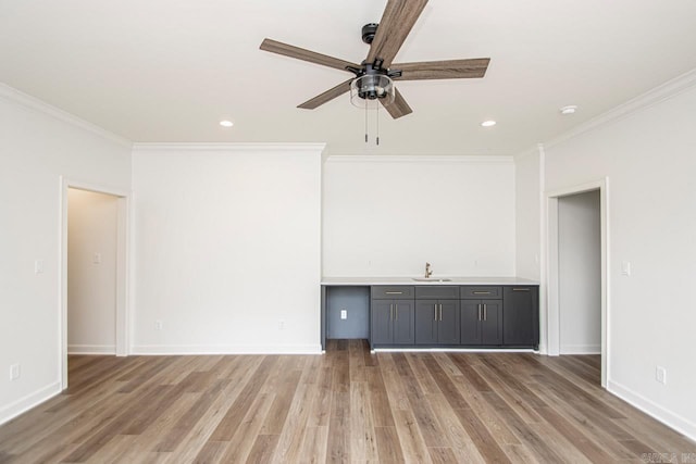 unfurnished living room with light hardwood / wood-style flooring, ornamental molding, and sink