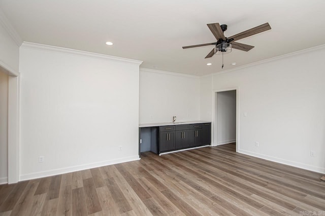 spare room with crown molding, sink, ceiling fan, and hardwood / wood-style flooring