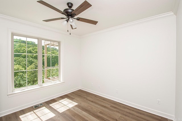 empty room featuring crown molding, ceiling fan, and dark wood-type flooring