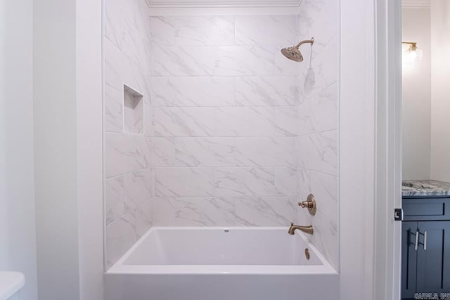 bathroom featuring vanity, ornamental molding, and tiled shower / bath