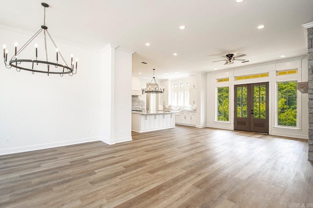 unfurnished living room with french doors, light hardwood / wood-style floors, ceiling fan, and ornamental molding