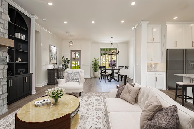 living room featuring hardwood / wood-style floors, a notable chandelier, and ornamental molding