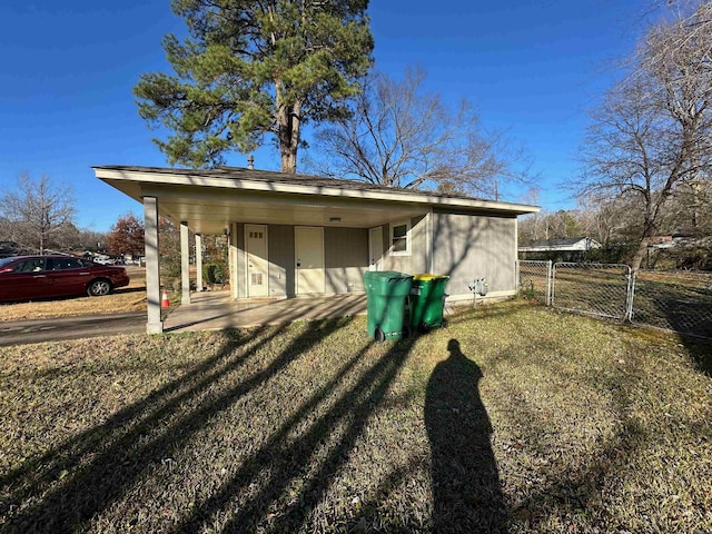 exterior space with a carport and a lawn