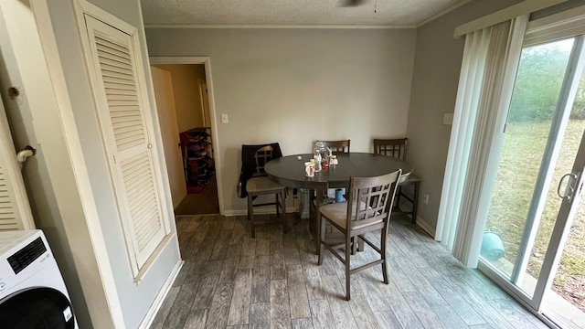 dining room with hardwood / wood-style floors, ornamental molding, a textured ceiling, and washer / dryer