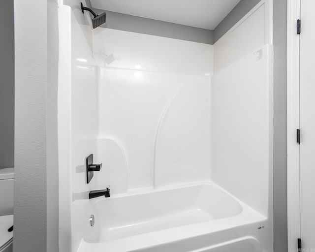 bathroom featuring shower / bathing tub combination and toilet