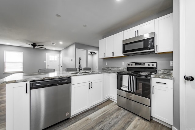 kitchen featuring white cabinets, sink, ceiling fan, kitchen peninsula, and stainless steel appliances