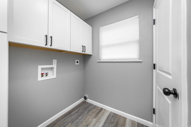 clothes washing area featuring hardwood / wood-style flooring, electric dryer hookup, cabinets, and hookup for a washing machine