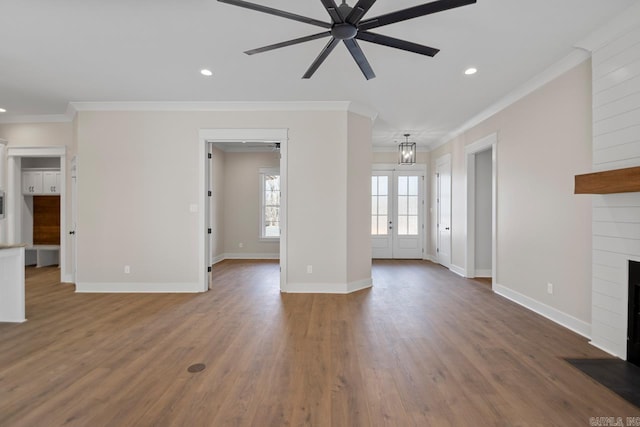 unfurnished living room featuring hardwood / wood-style flooring, ceiling fan with notable chandelier, ornamental molding, and french doors