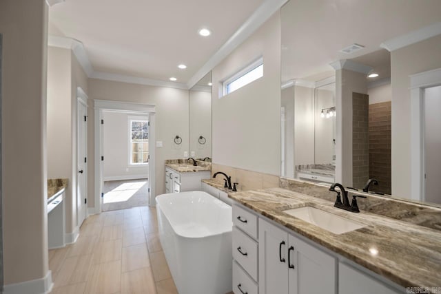 bathroom featuring a bathing tub, a wealth of natural light, vanity, and ornamental molding