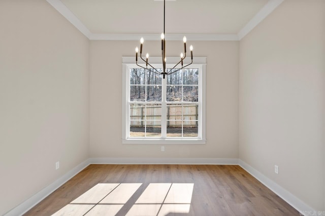 unfurnished dining area with crown molding, a chandelier, and light wood-type flooring