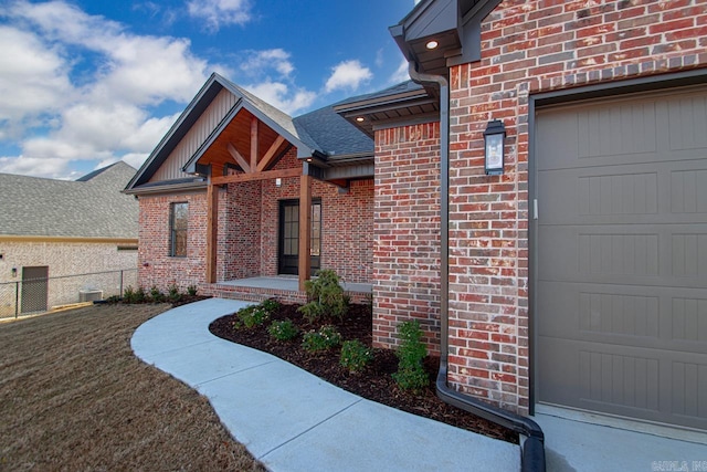 view of exterior entry with a yard and a garage