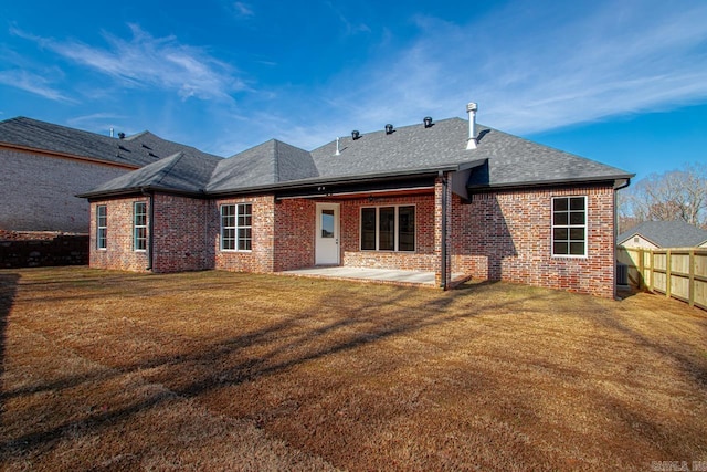 rear view of house with a yard and a patio