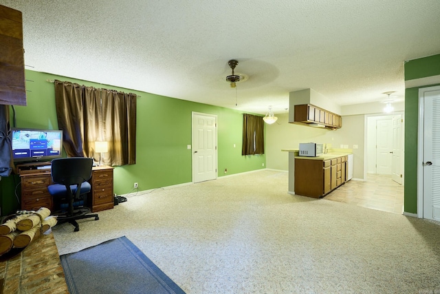 carpeted home office with a textured ceiling and ceiling fan