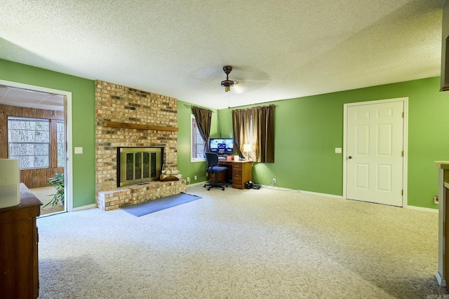 unfurnished living room featuring carpet flooring, a textured ceiling, a fireplace, and ceiling fan