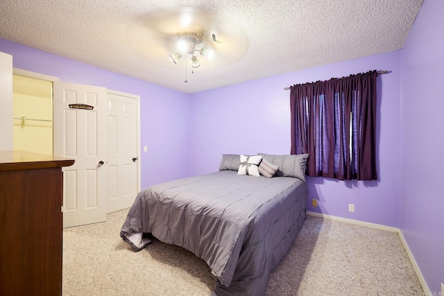 bedroom featuring light carpet and a textured ceiling