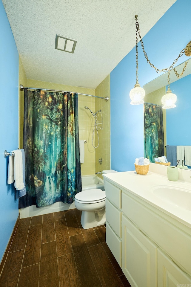 full bathroom with shower / tub combo with curtain, vanity, a textured ceiling, and toilet