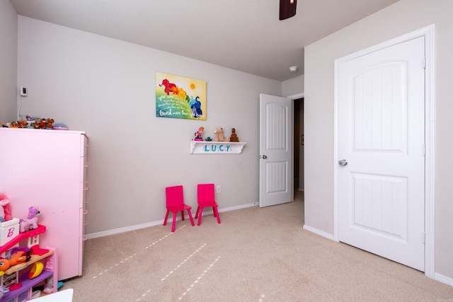 recreation room featuring light carpet and ceiling fan