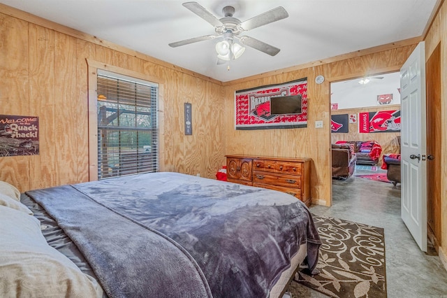 bedroom with ceiling fan and wooden walls