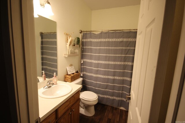 bathroom with wood-type flooring, vanity, toilet, and walk in shower