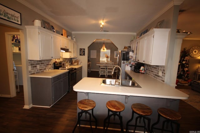 kitchen featuring white cabinets, dark hardwood / wood-style floors, kitchen peninsula, and appliances with stainless steel finishes