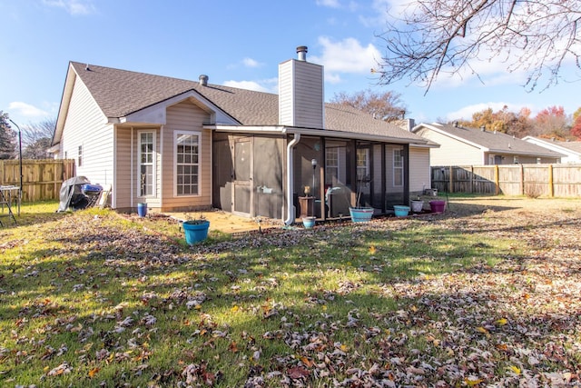 back of property with a sunroom and a yard