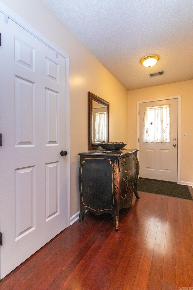 foyer with a textured ceiling and dark wood-type flooring