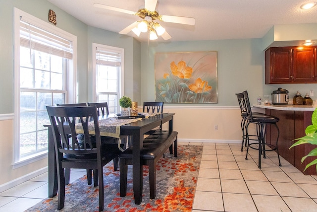 dining space featuring plenty of natural light, light tile patterned flooring, a textured ceiling, and ceiling fan