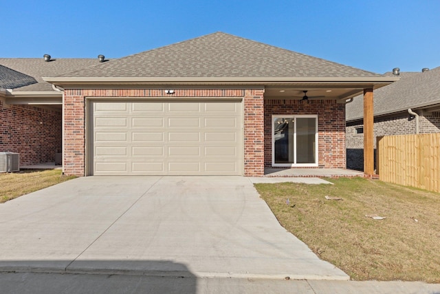 view of front of house featuring a front lawn, a garage, and cooling unit