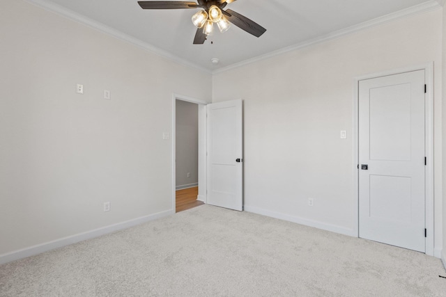 unfurnished room with ceiling fan, ornamental molding, and light carpet