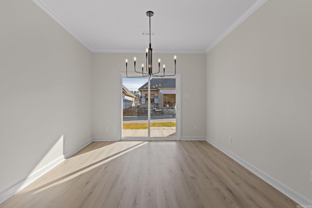 unfurnished dining area featuring light hardwood / wood-style floors, ornamental molding, and a notable chandelier