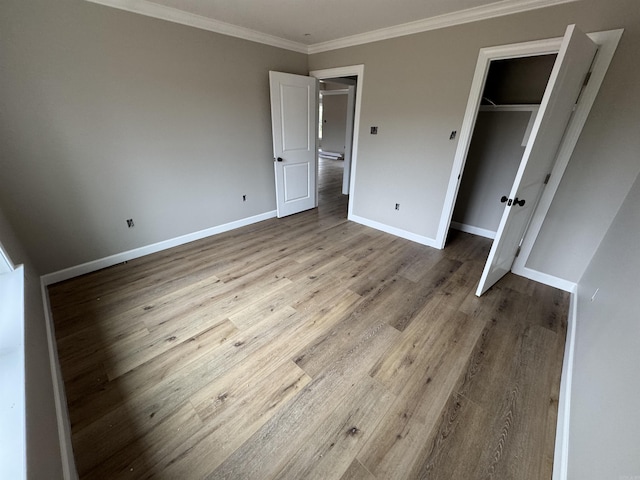 unfurnished bedroom featuring light hardwood / wood-style flooring, a closet, and ornamental molding