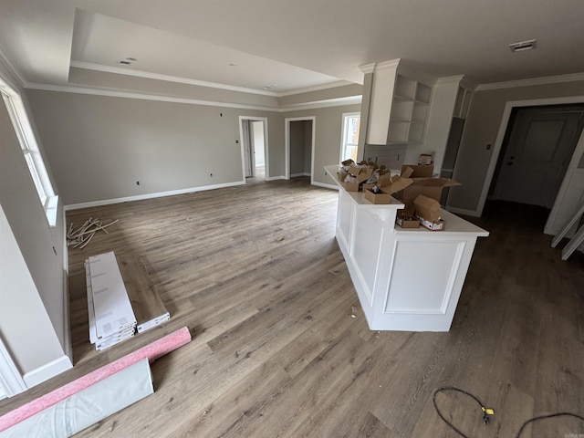 kitchen with white cabinetry, crown molding, and hardwood / wood-style flooring