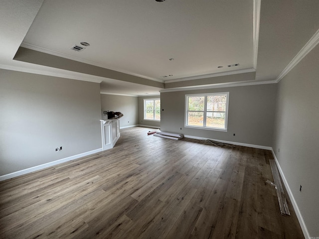 unfurnished living room featuring a tray ceiling, ornamental molding, and hardwood / wood-style flooring