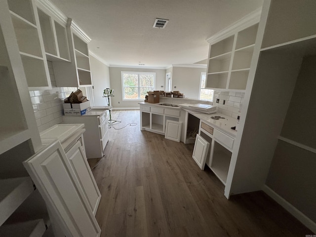 kitchen with decorative backsplash, white cabinetry, kitchen peninsula, and light hardwood / wood-style floors