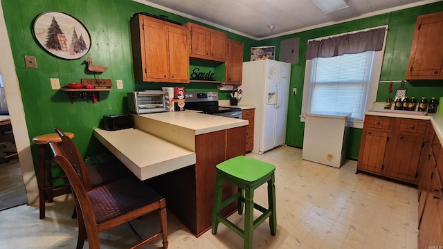 kitchen with kitchen peninsula, a breakfast bar, crown molding, electric range, and white fridge with ice dispenser