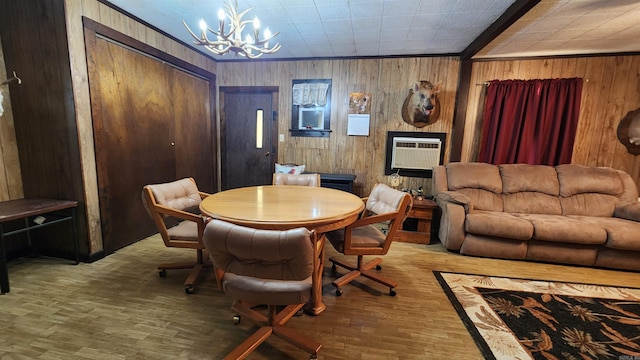 dining area with a notable chandelier, wood-type flooring, wooden walls, and a wall mounted AC