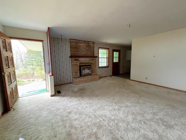 unfurnished living room with plenty of natural light, light colored carpet, and a fireplace