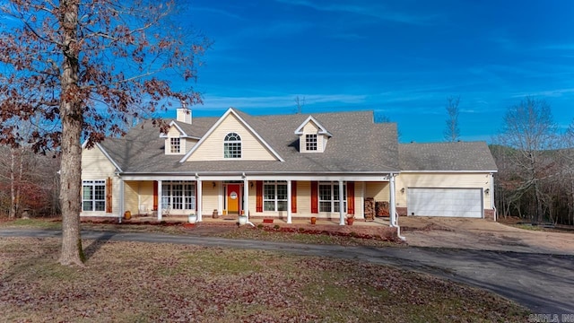 cape cod home featuring a porch and a garage