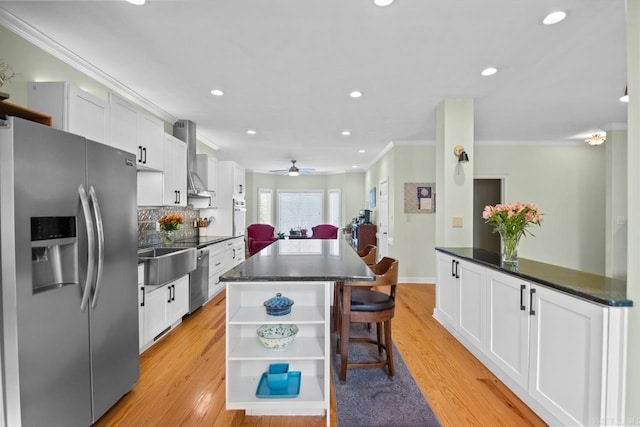 kitchen featuring decorative backsplash, white cabinets, stainless steel appliances, and light hardwood / wood-style floors